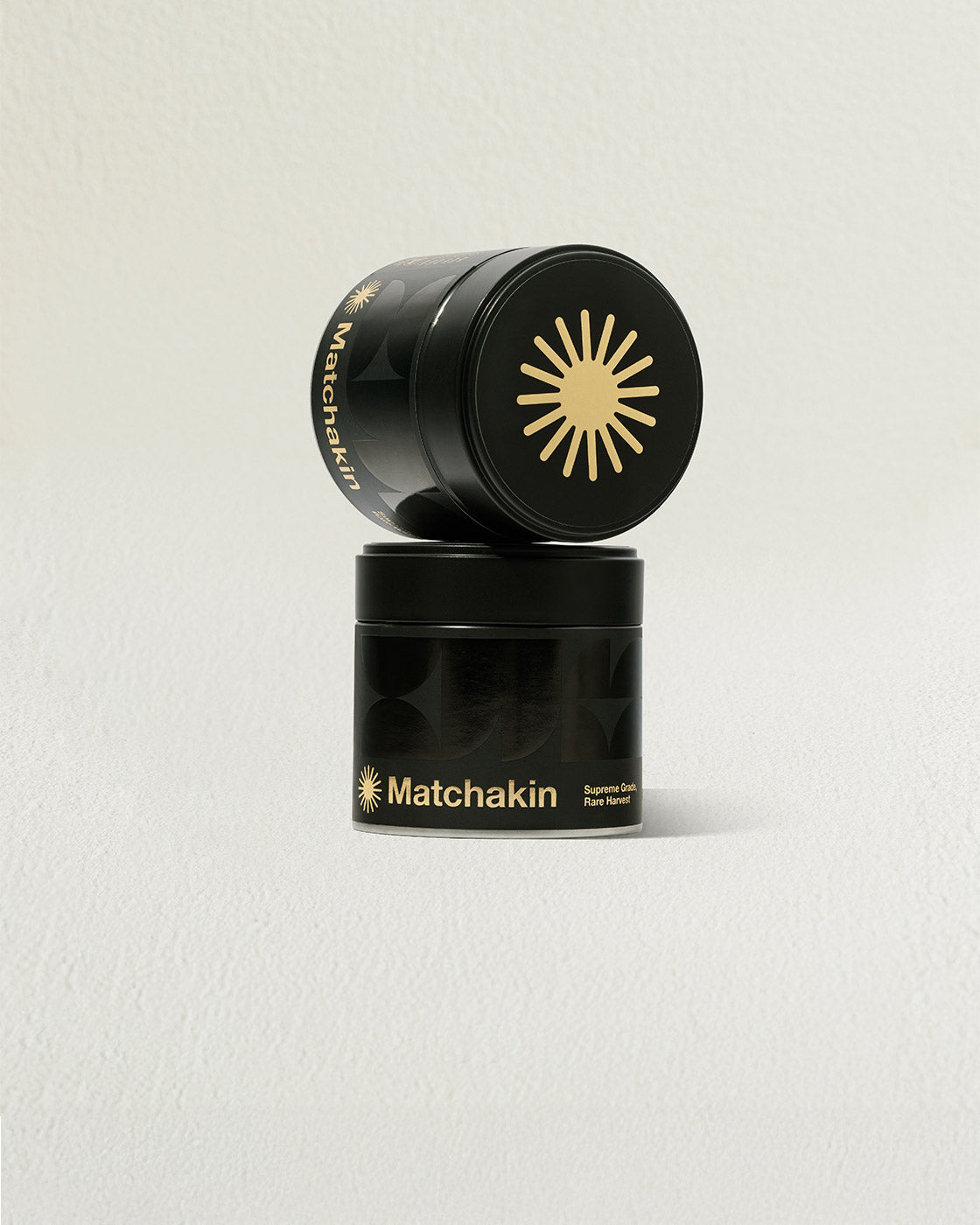 Two black containers with gold accents stacked on a light gray background, featuring the brand 'Matchakin'.